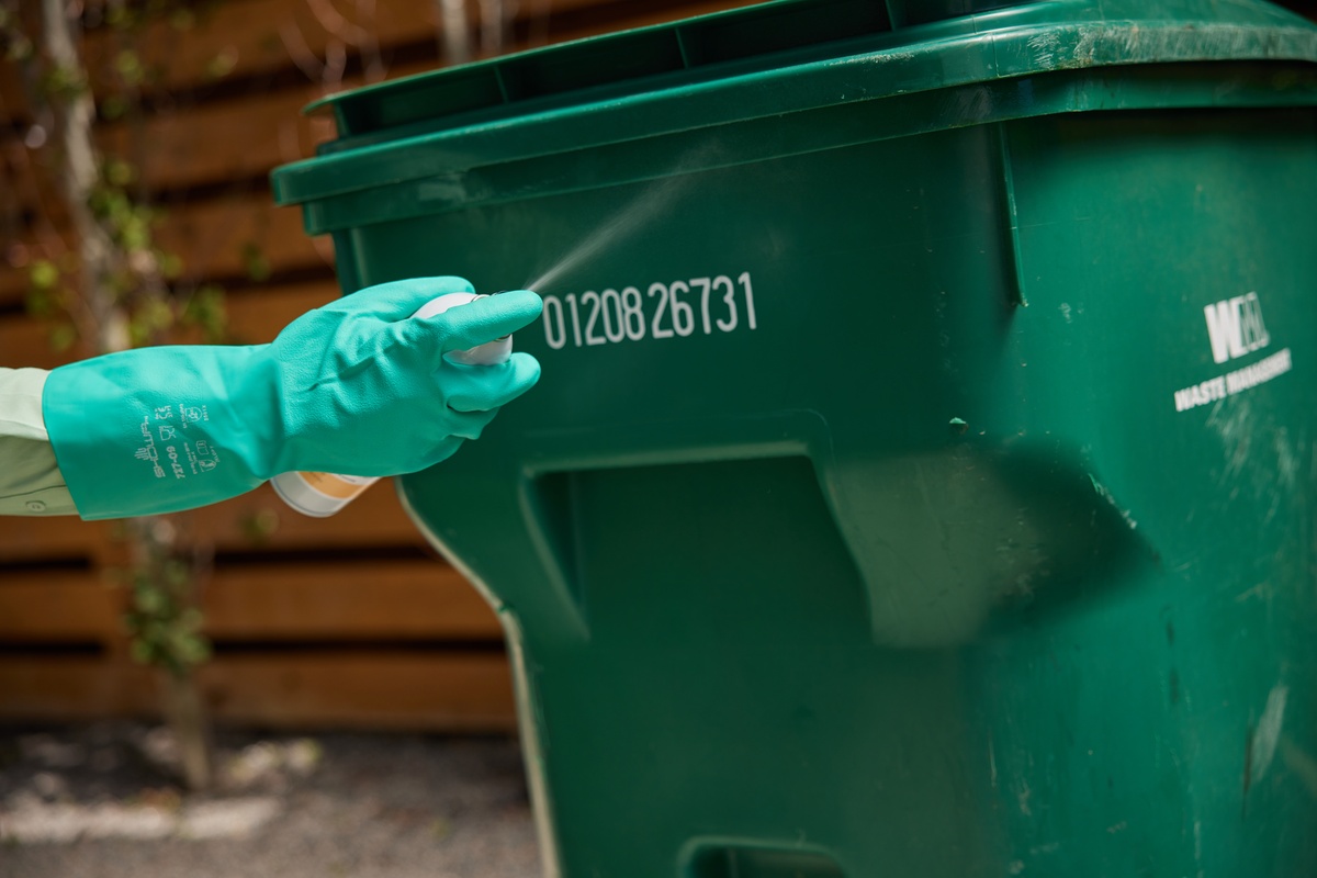 Service pro treating customer's garbage can