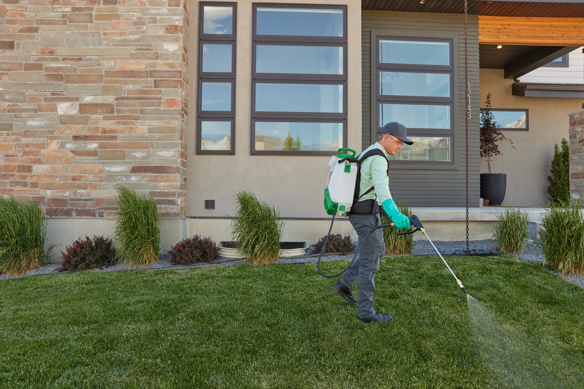 Service pro spraying for pests in customer's front lawn