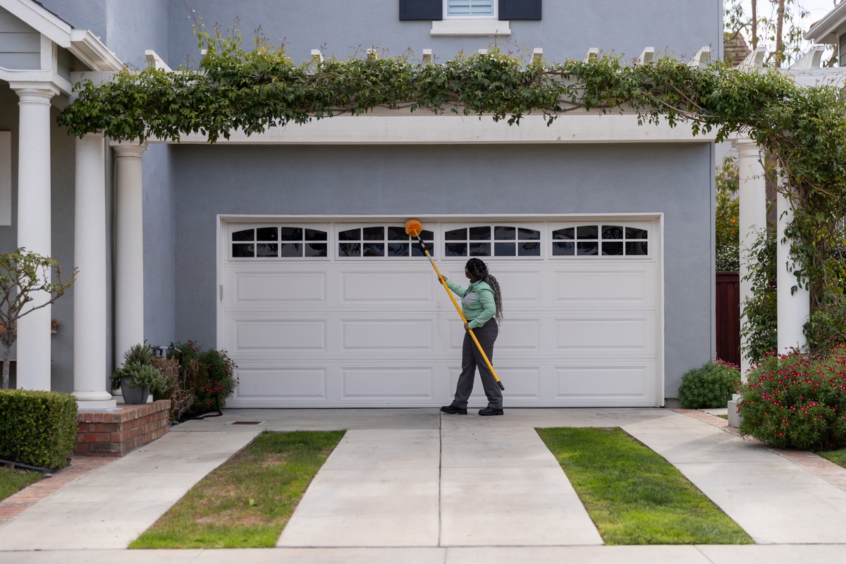 Pest Control Service Sweeping for Spiders by Garage Service pro sweeping for spiders by customer's garage